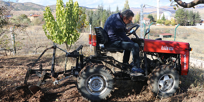 Emekli öğretmen bahçe işlerinde kendi yaptığı traktörü kullanıyor